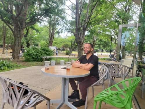 Cristian Dávila sitting outside of a Cafe (that is joined to a Library) in Itabashi Tokyo Japan 2022