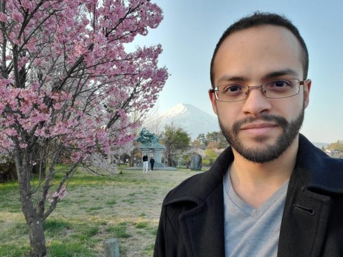 Cristian Dávila posing in front of a Sakura Tree  Mt Fuji in Fujikawaguchiko Japan 2023